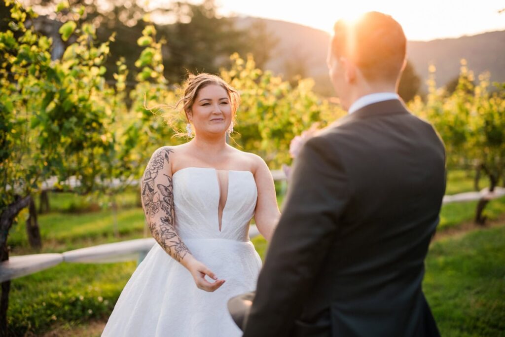 A couple in wedding attire walks in the vineyard at the Farmhouse at Veritas during their intimate wedding near Charlottesville