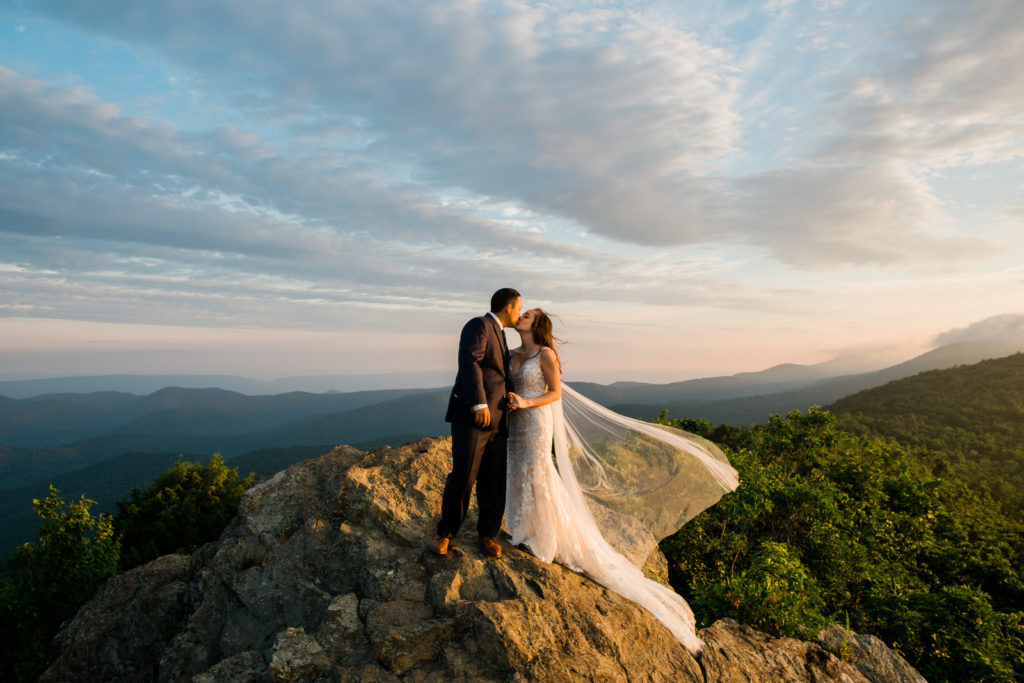 A couple embraces on a mountaintop during their elopement