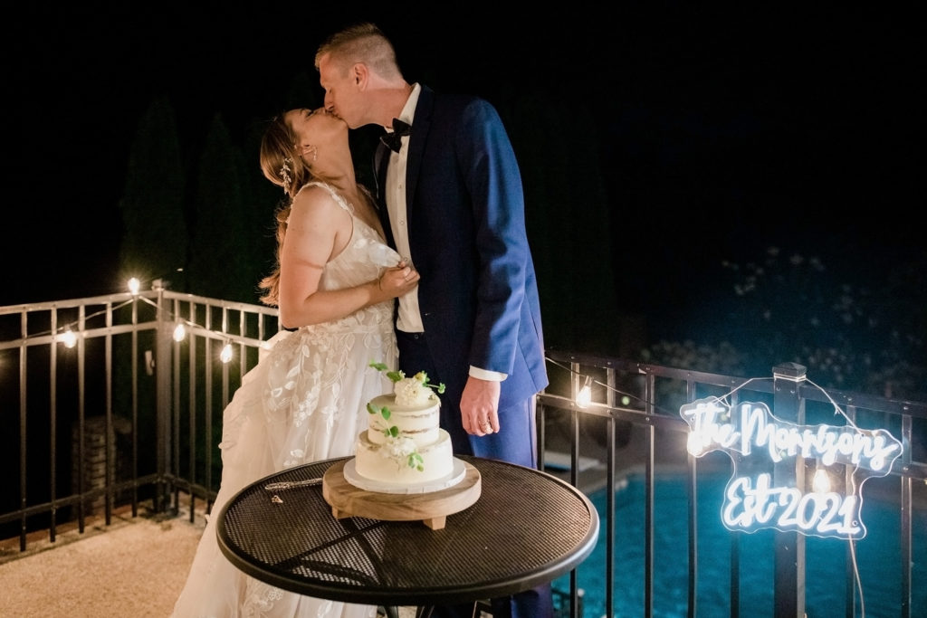 A couple kiss after cutting the cake at their Airbnb reception