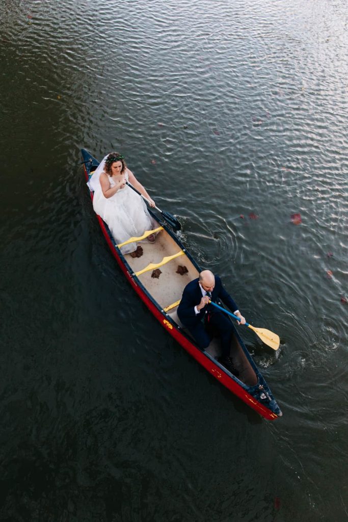 A bride and groom canoe in a red canoe
