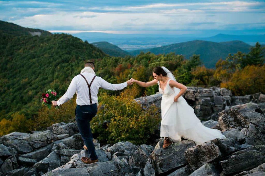 A couple walks across a rocky summit after their elopement