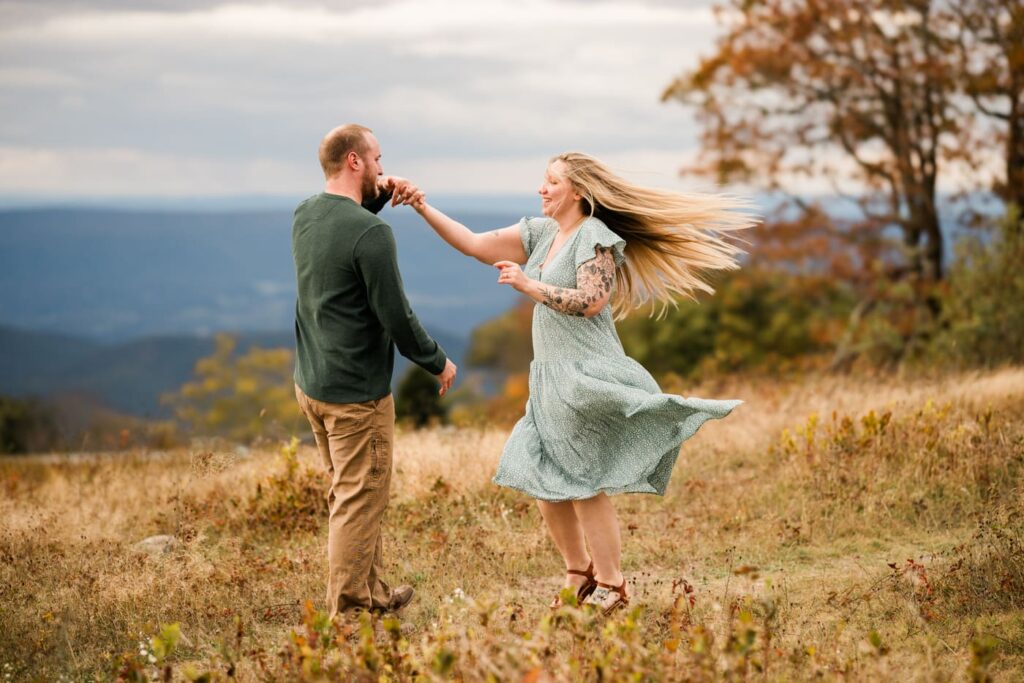 A couple dances in Big Meadows at Shenandoah National Park during their engagement photo session. 