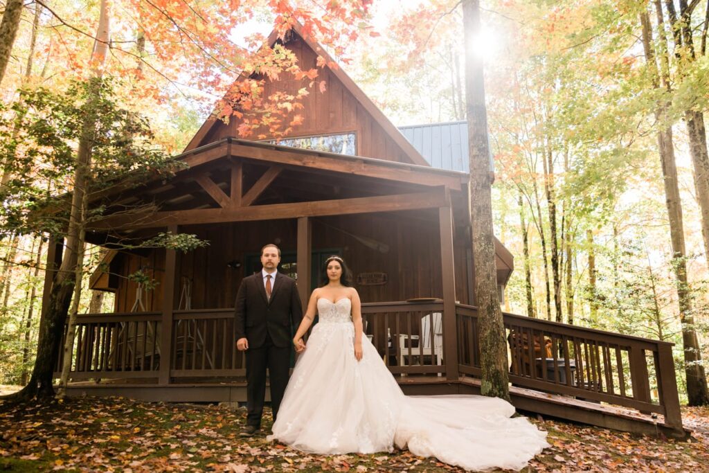 A couple stands in front of the A Fram Cabins at Summersville Lake in wedding attire