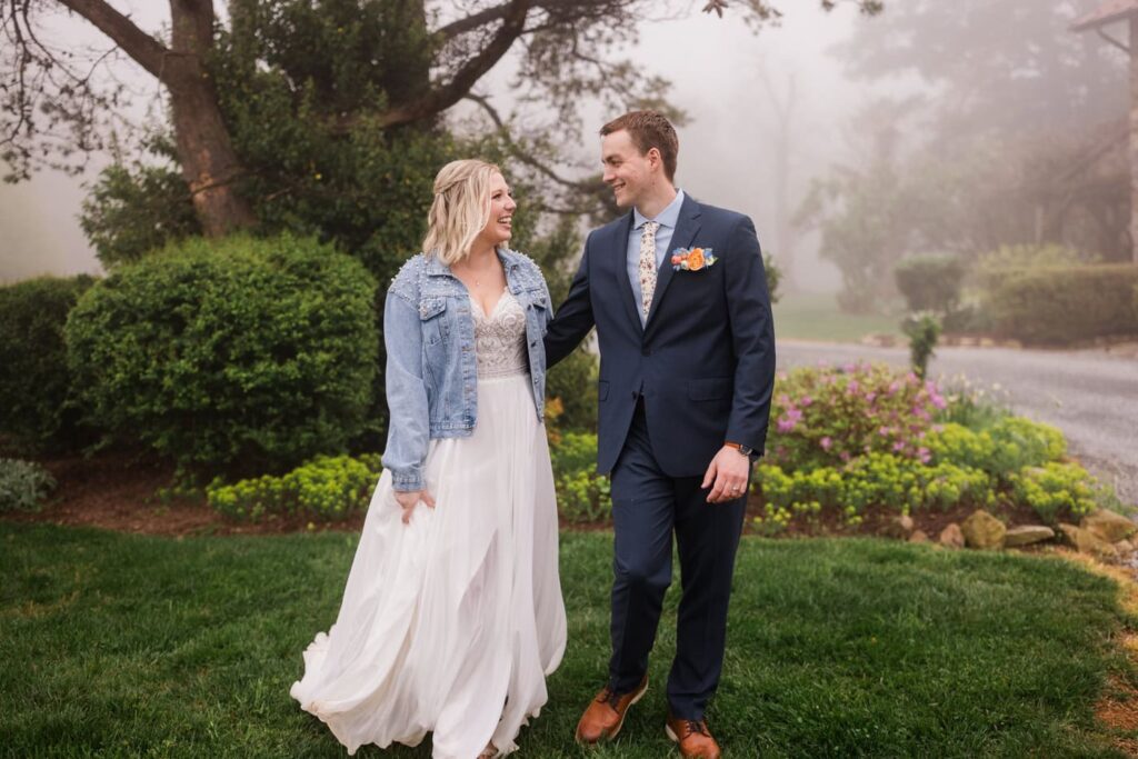 A couple walks toward the camera during the portrait section of their foggy micro wedding at Bear Chase Manor