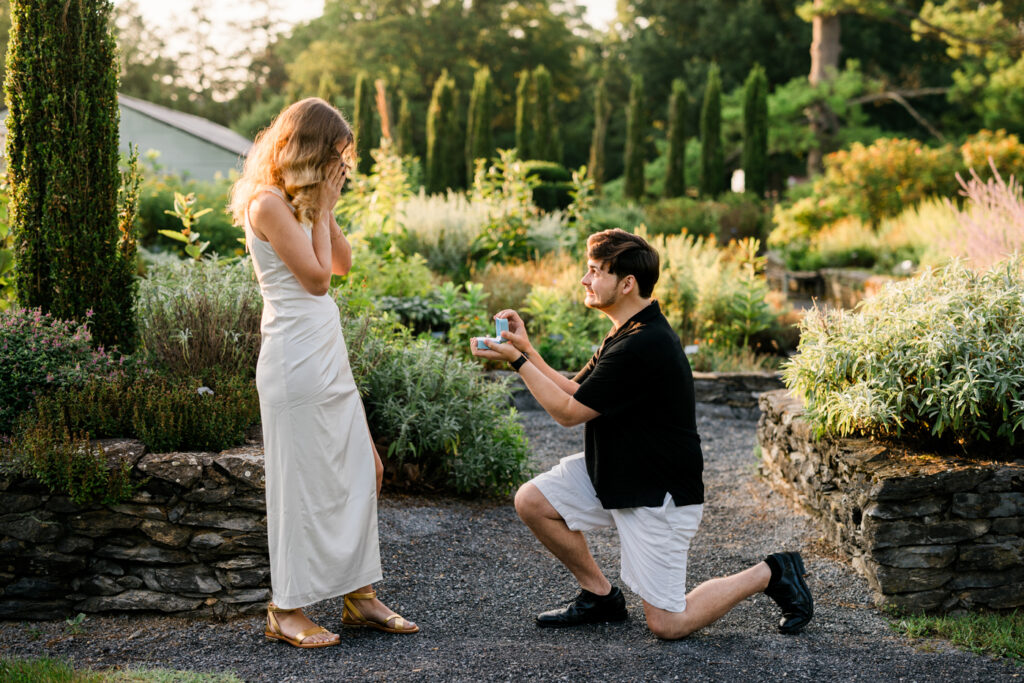 A man gets down on one knee to propose to his girlfriend. 