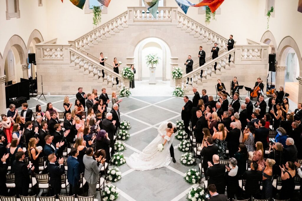 A couple dips on their way back down the aisle during their Chrysler museum of art wedding