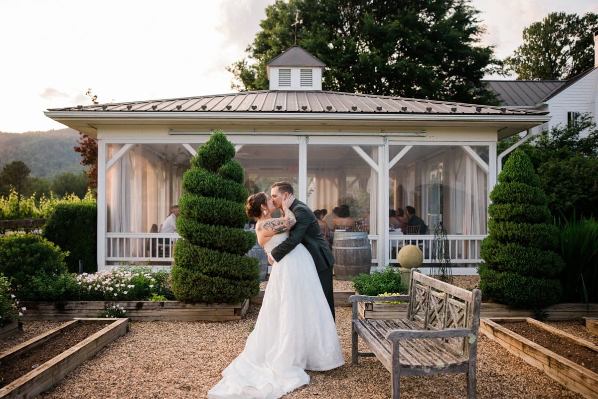 A couple kisses during their micro wedding at the Farmhouse at Veritas in Afton near Charlottesville