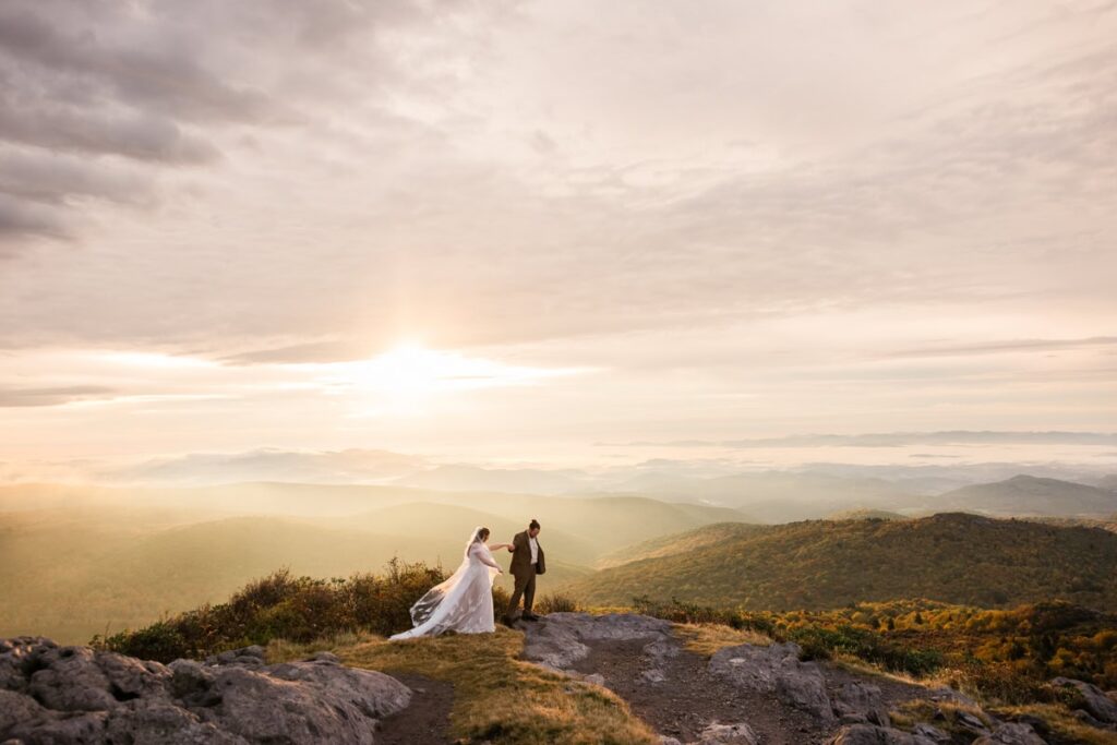 A couple in wedding attire stands on top of Wilburn Ridge Summit